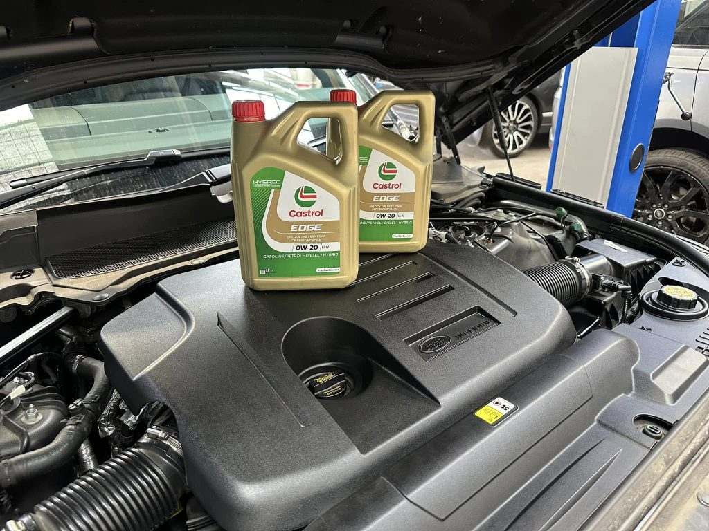Servicing page image: Two Castrol Edge oil bottles standing on top of a Land Rover engine in the A.S.M Independent garage. ASM Independent: Independent Jaguar and Land Rover Specialists Wakefield.